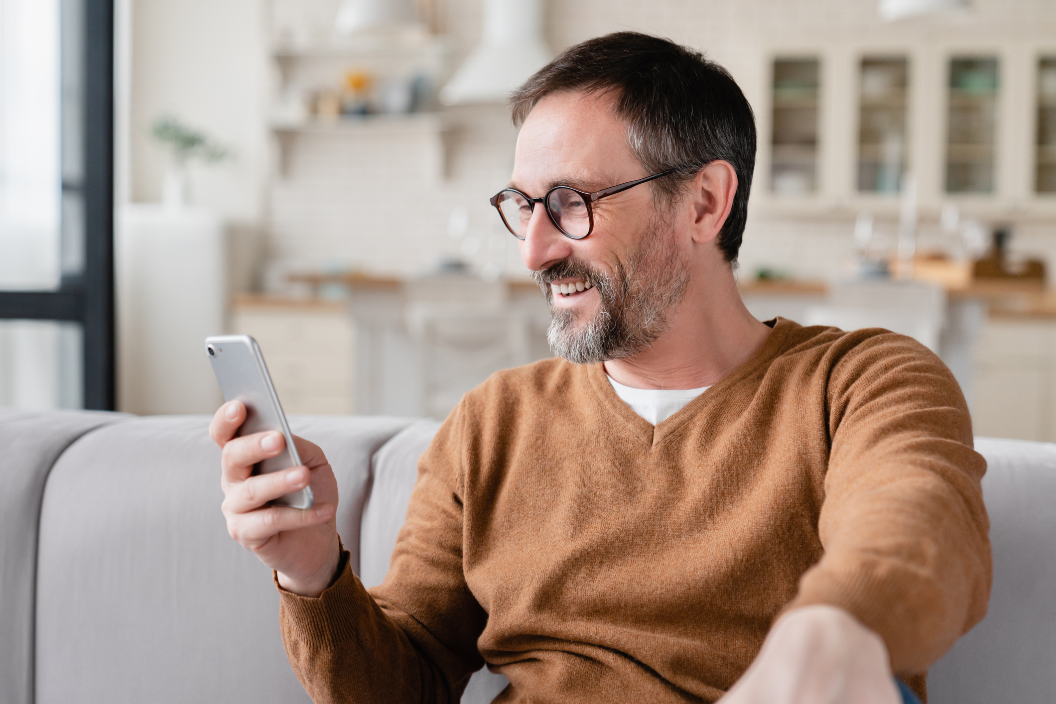Patient smiling while reading a text message on a phone